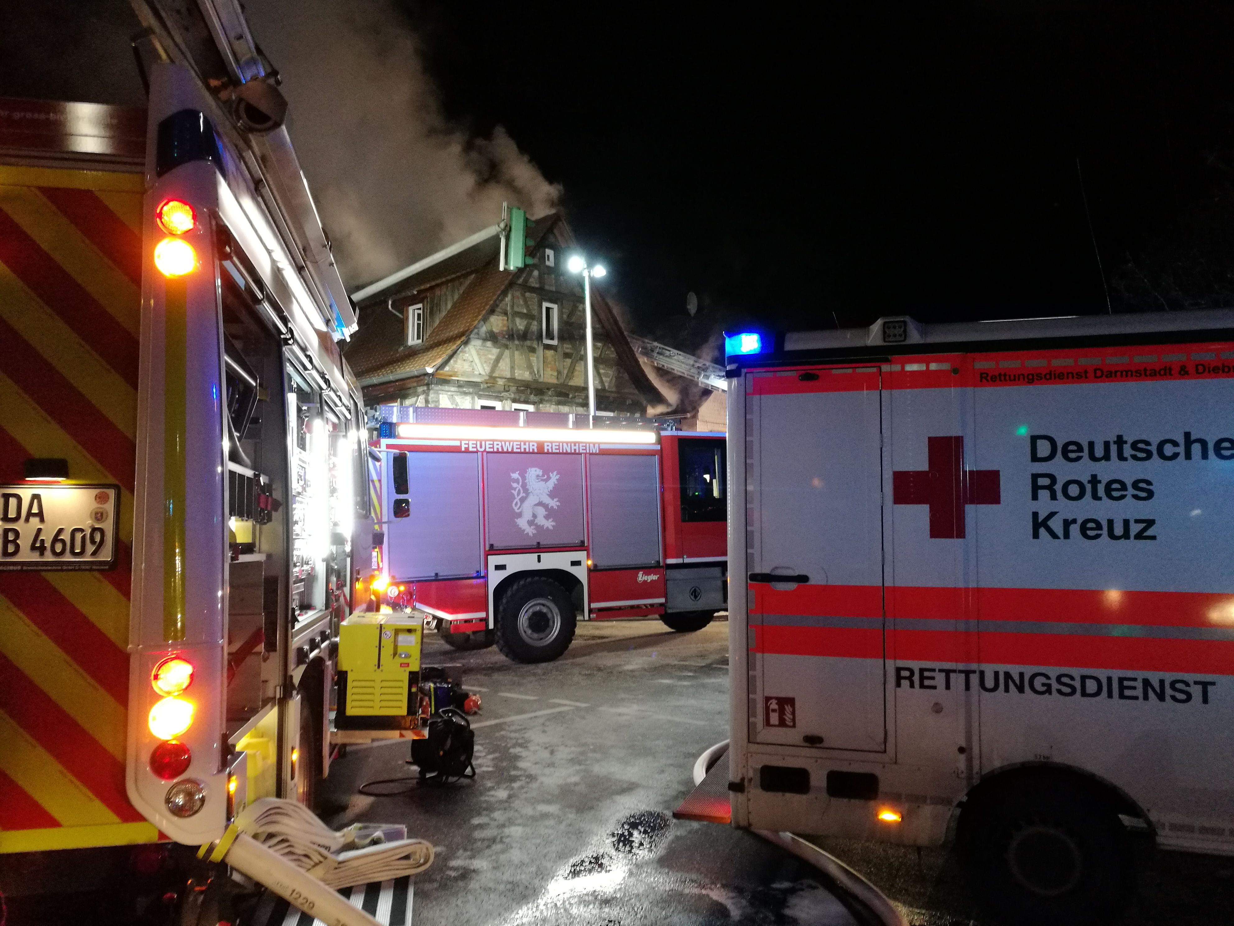Foto: Zu sehen ist ein DRK-Rettungswagen von vorne in schneller Fahrt. Fahrer und Beifahrer konzentrieren sich auf die Fahrt.