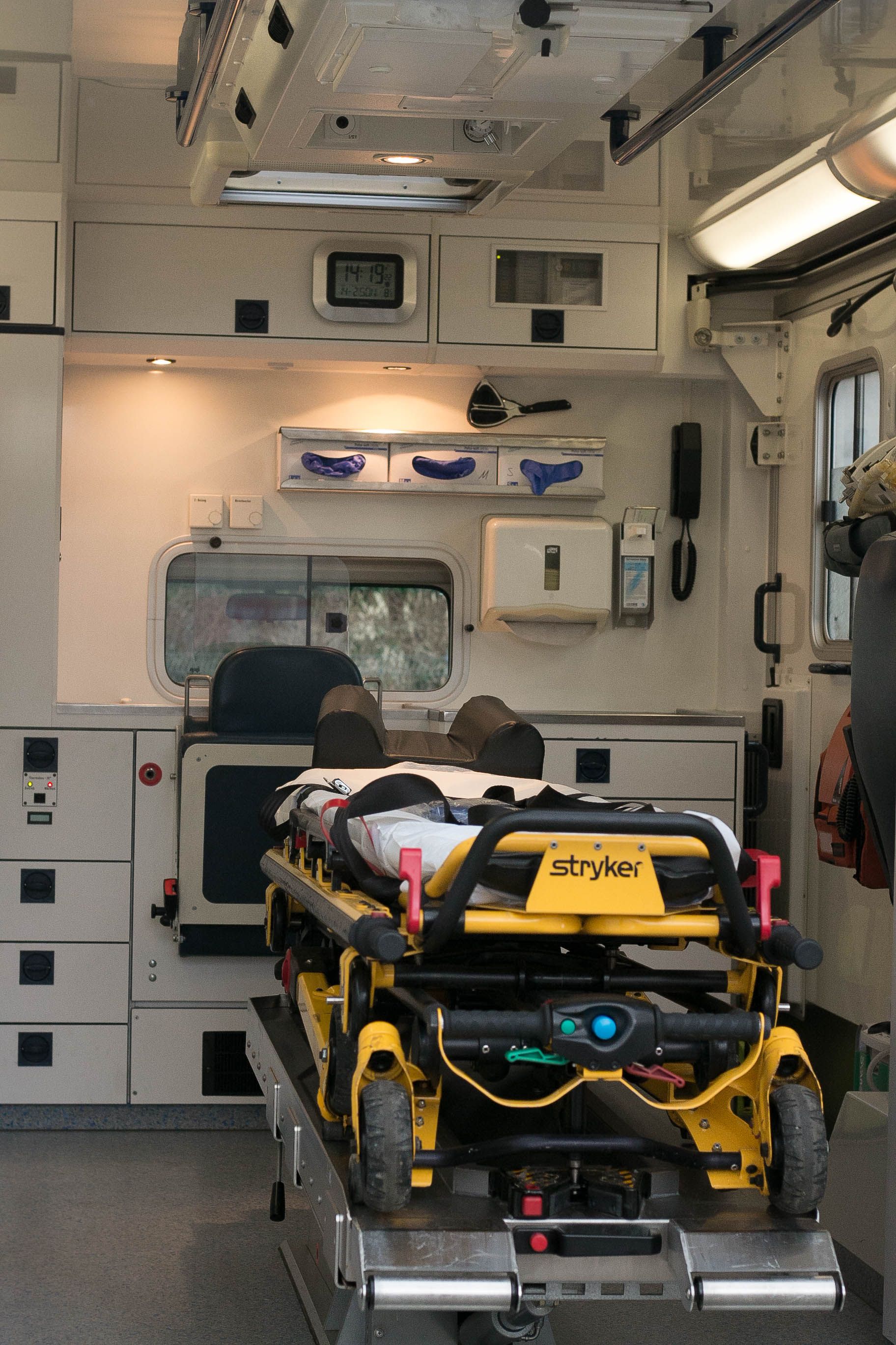 Foto: Ein DRK-Rettungssanitäter steht mit Notfallausrüstung vor einem Rettungswagen.