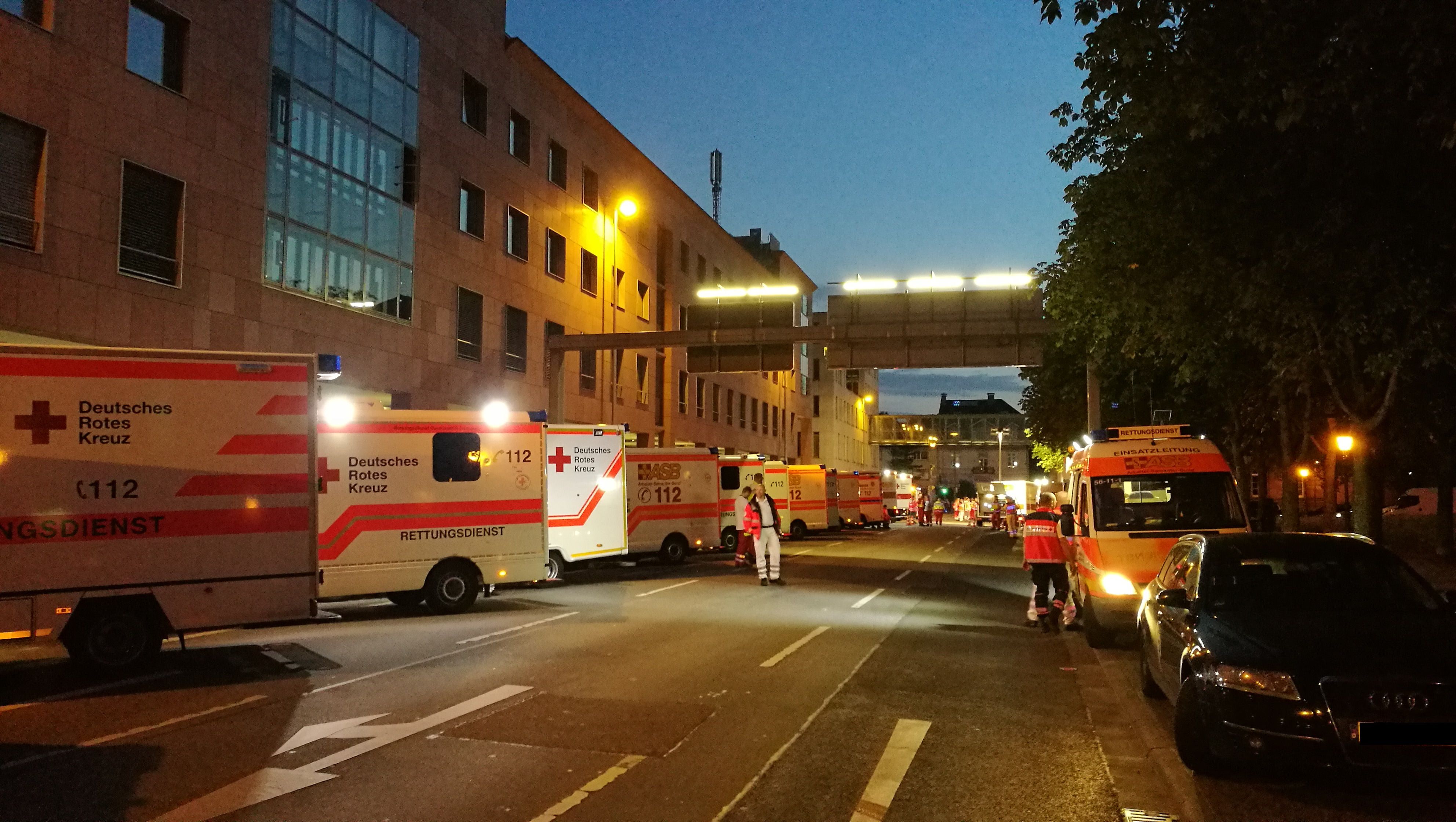 Foto: Zu sehen ist ein DRK-Rettungswagen von vorne in schneller Fahrt. Fahrer und Beifahrer konzentrieren sich auf die Fahrt.